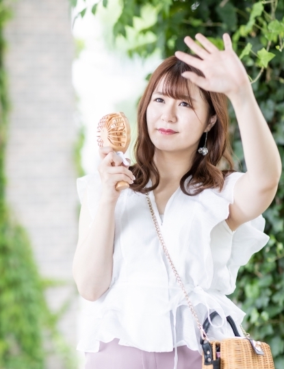 ハンディファンで冷を取る若い女性