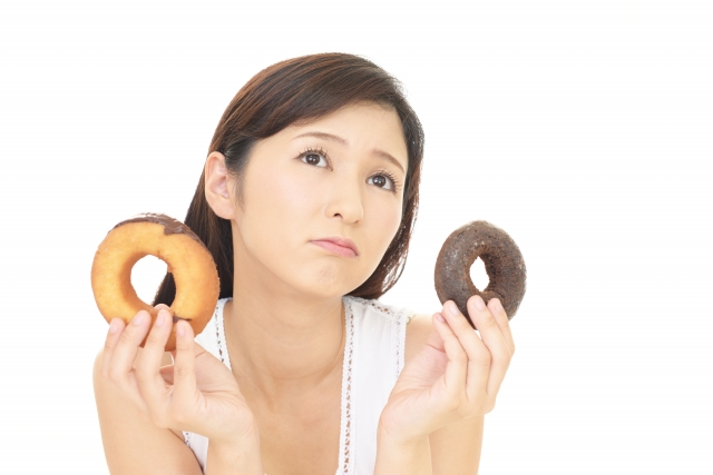 菓子パンを手に持つ女性