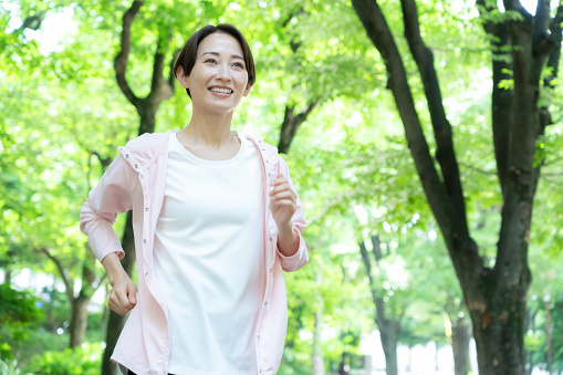 公園の中を走るミドル女性