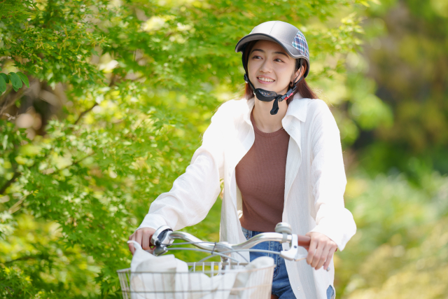 公園の中を自転車で走る女性