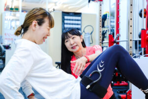 加圧トレーニングでキツさを感じて運動する女性メンバー。