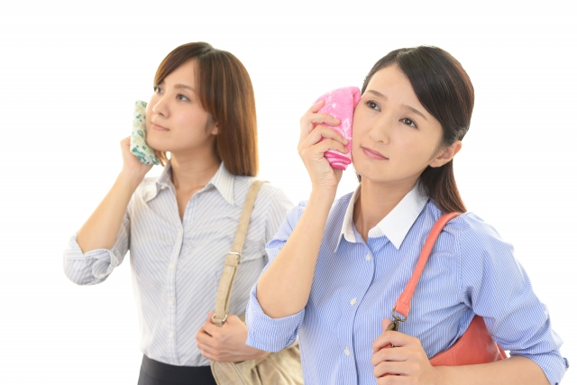 書いた汗をハンカチでぬぐう二人の女性
