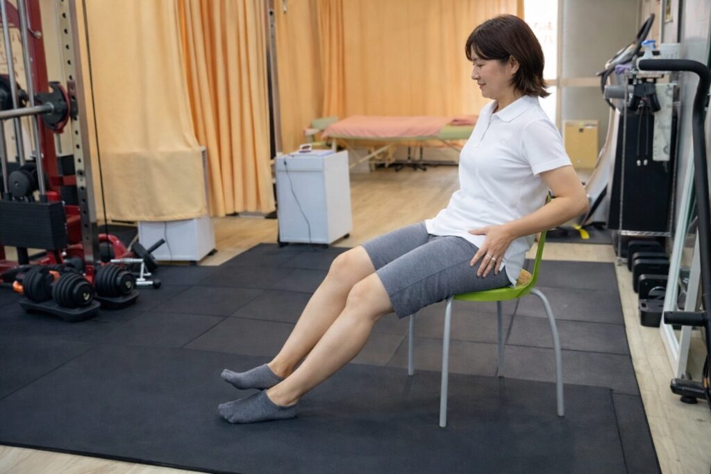 椅子に座り、床に両足を軽く押し当てる運動