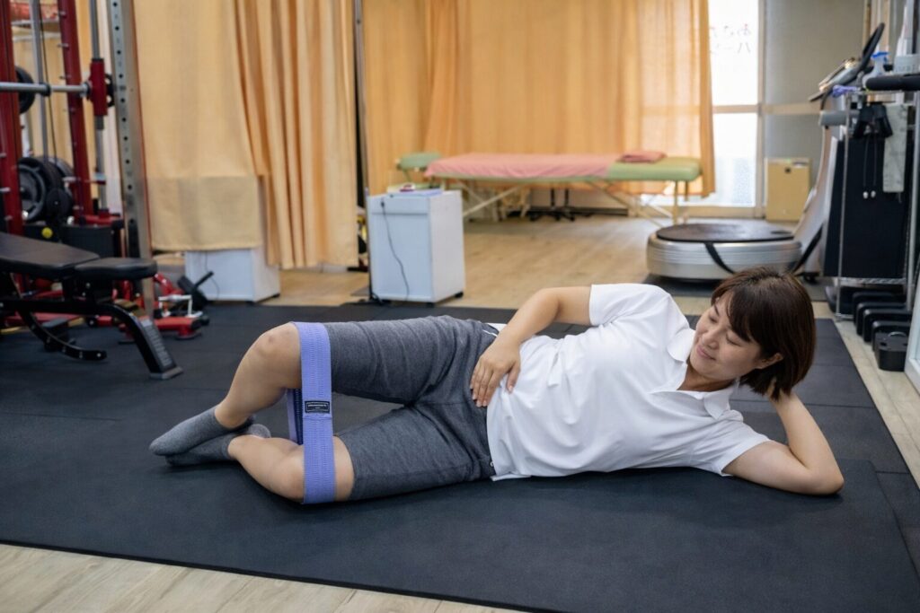 横向きに寝て、軽く膝を曲げて上側の膝を開閉する運動