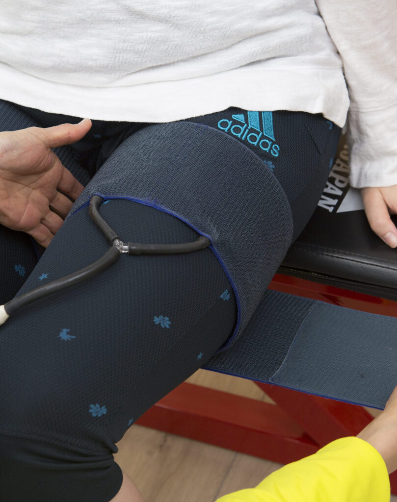 脚の付け根に太いベルトを巻いて、圧を入れる。加圧トレーニング（駆血法の画像）