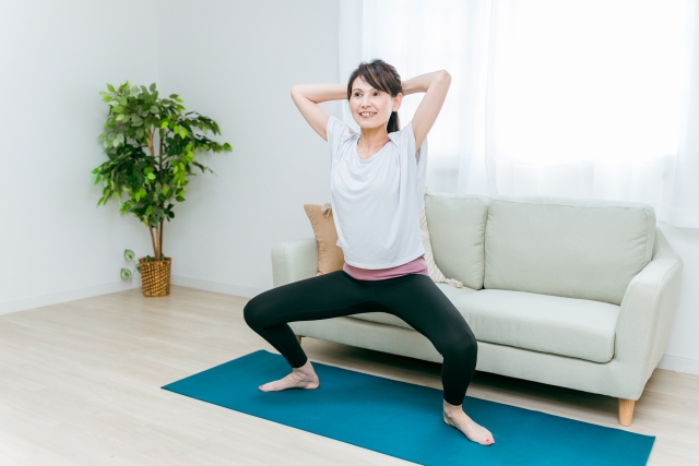 自宅でスクワット運動するミドル女性