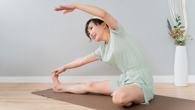 お風呂上がりに自宅でストレッチする女性