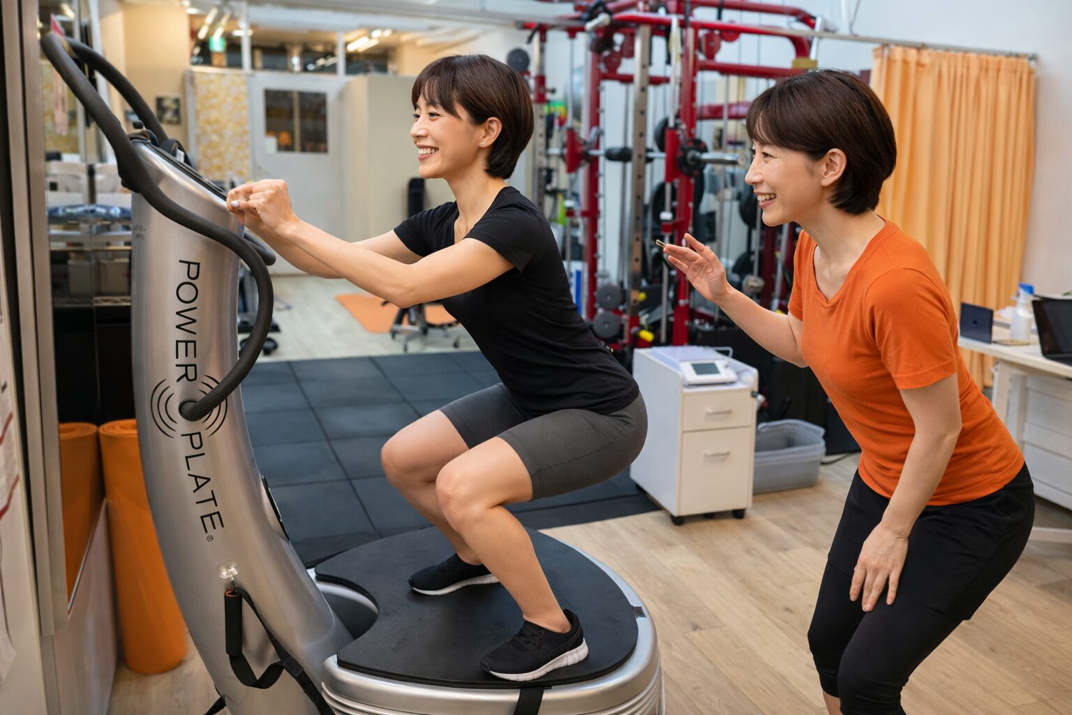 パワープレートでスクワット運動を指導するスタッフ