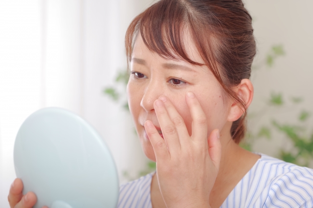 鏡で老けた顔にがっかりする女性