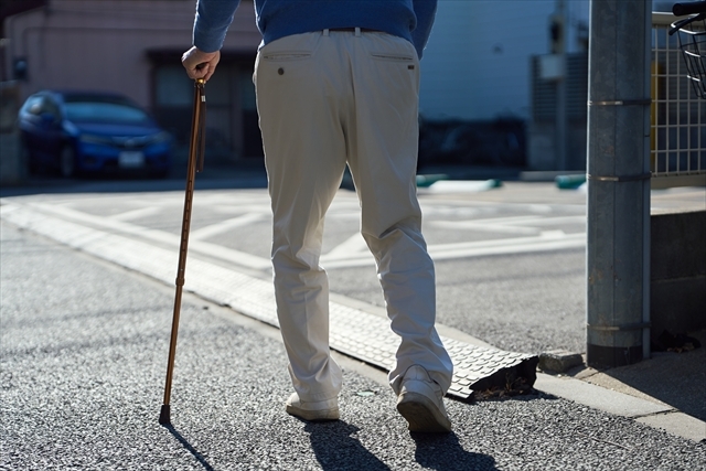 杖をついてとぼとぼ歩くシニア男性
