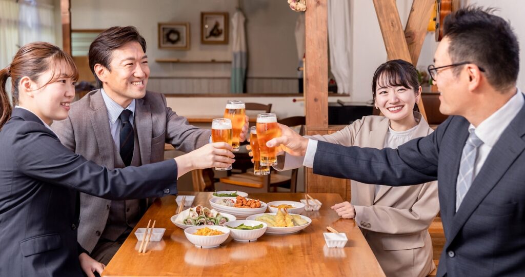 仕事仲間たちと楽しく宴会する4人。