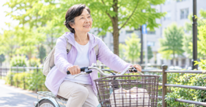 街中を自転車に乗って移動する70代女性