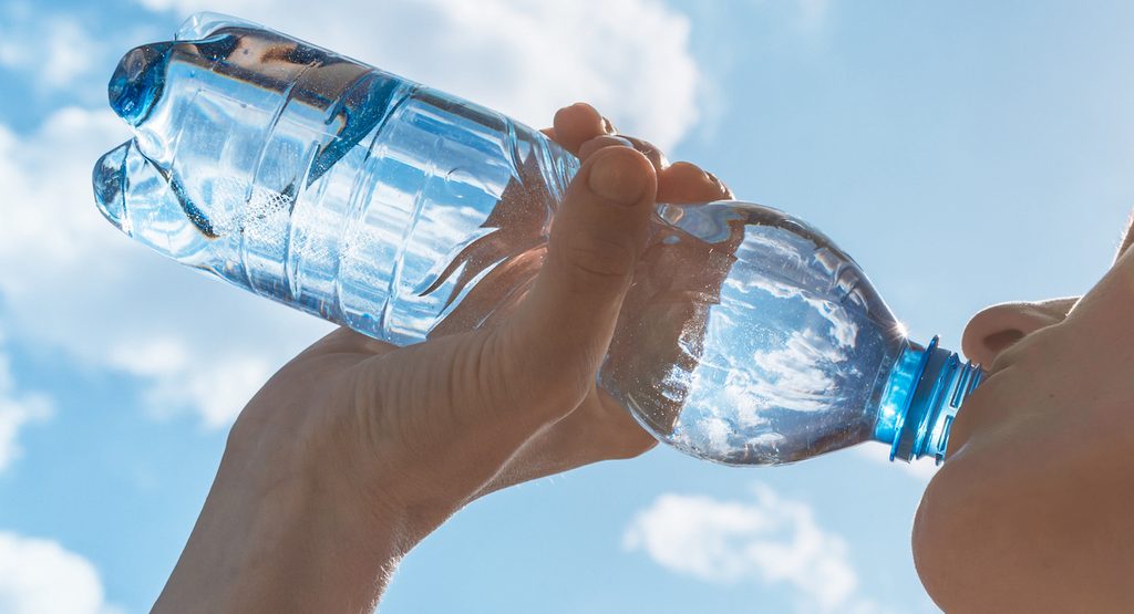 ペットボトルの水を飲む女性