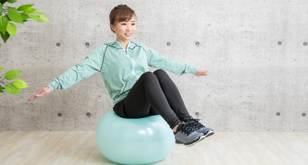 バランスボールで健康的にダイエットする女性。