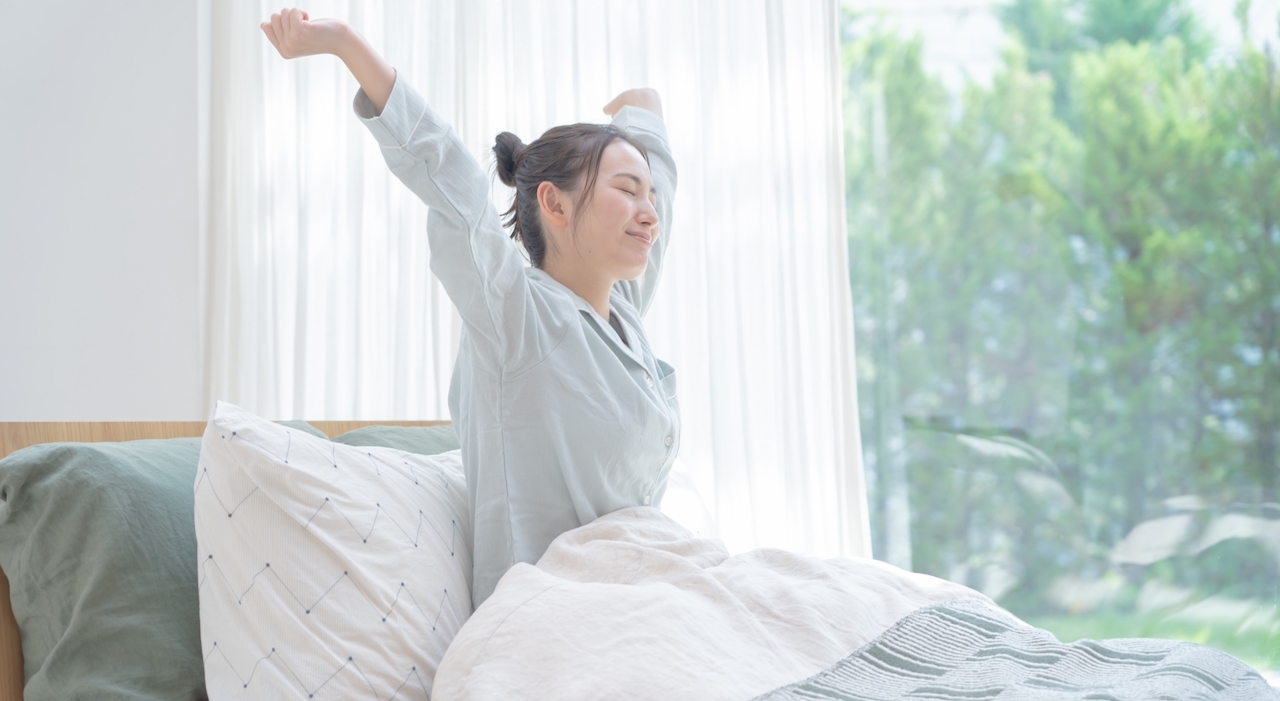良い睡眠で気持ちよく起きる女性