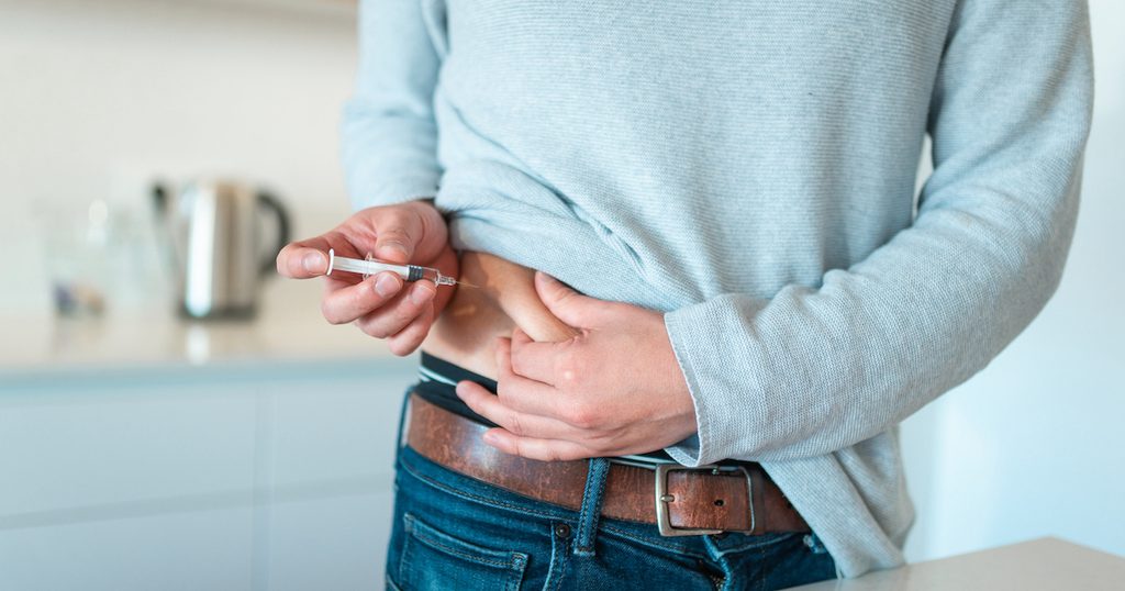 糖尿病の薬をお腹に注射する男性